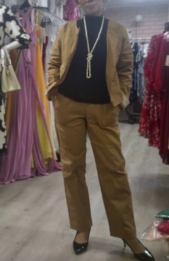 Model wearing a tan jacket/top, black turtleneck, and tan pants.